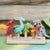 Set of colorful dinosaur toys on a wooden stand with a wooden background