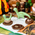 Plush dinosaur toys on an open book with a toy forest in the background