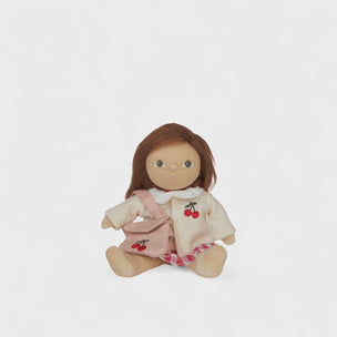 Small doll with brown hair and a pink outfit on a white background