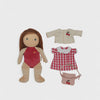 Doll with a red swimsuit and three pieces of clothing on a light gray background