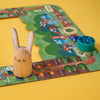 Wooden rabbit figure on a children's board game with a yellow background