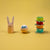Wooden toy rabbit, ball with 'Go!' text, and stack of colorful rings on a yellow background