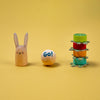 Wooden toy rabbit, ball with 'Go!' text, and stack of colorful rings on a yellow background