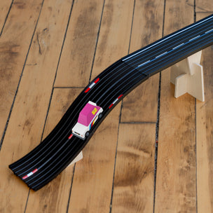 Toy car on a black track on a wooden floor