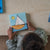 Child playing with a wooden sailboat puzzle on a wooden table