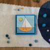 Wooden puzzle with a sailboat design on a textured surface