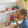 Child playing with colorful wooden blocks on a shelf