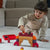 Child playing with building blocks on a carpeted floor