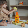 Child playing with colorful wooden toys on a carpeted floor.