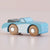 Toy car with blue body and wooden wheels on a light background