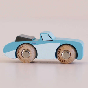 Wooden toy car with blue body and wooden wheels on a light gray background