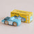 Wooden toy car with 'Le Toy Van' packaging on a beige background