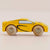 Yellow toy car with wooden wheels on a beige background