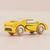 A yellow wooden toy sports car with hand-painted black and light blue details, photographed on a soft beige background.