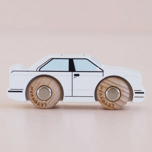 Toy car with wooden wheels on a beige background