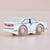 Wooden toy car with white body and black details on a beige background
