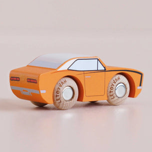 Orange toy car with wooden wheels on a beige background