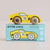 A yellow wooden toy race car with brown wheels sits on top of its light blue retail box. The box is labeled 'GT135 LUCA' and 'Limited Edition' and shows the same car design with the number 11.