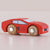 Red toy car with wooden wheels on a light pink background