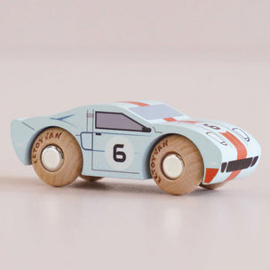 Wooden toy car with a light blue body, red and black accents, and the number 6 on a beige background.