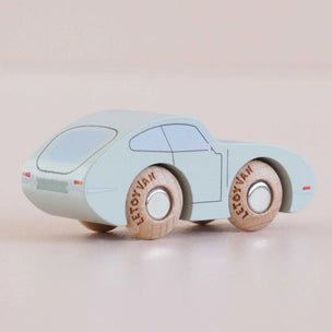 Light blue toy car with wooden wheels on a beige background