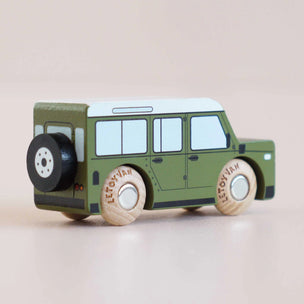 Toy vehicle with wooden wheels on a beige background