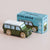 Green toy van with white roof next to its packaging on a beige background