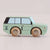 A pastel mint green wooden toy car with natural wood wheels, shown in profile against a light beige background.