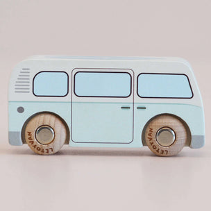 A wooden toy bus with a light blue body and natural wood wheels, shown from a side profile against a solid light beige background.