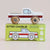 A wooden toy pickup truck labeled 'LET'S GO! TAM' sits on top of its lime green retail box, which reads 'GT165 CHARLIE Limited Edition' and shows the same truck illustration. The truck is white with a red stripe and natural wood wheels, photographed against a plain light beige background.