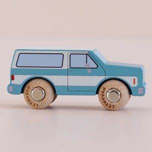 Toy van with wooden wheels on a light beige background