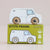 A wooden toy van labeled 'GT175 FRANK' sits on top of its matching green packaging box. The van has a white body with light blue window details and natural wood wheels.