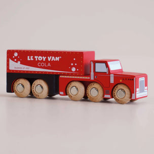 Red toy truck with wooden wheels from Le Toy Van on a beige background