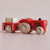Red toy truck with wooden wheels on a light beige background
