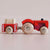 Wooden toy tractor with a trailer on a beige background