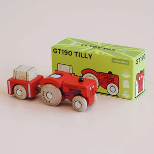 Wooden toy tractor with a green box labeled 'GT190 TILLY' on a beige background