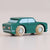Green toy car with wooden wheels on a beige background