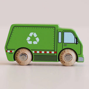 a greeen garbage toy truck facing sideways with a beige background 