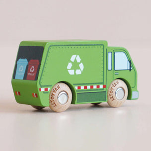 Green toy recycling truck with wooden wheels on a light background