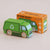 a green toy recycle truck acing sideways facing the packaging box 