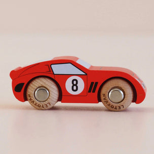 Red wooden toy car with the number 8 on a beige background