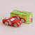 A red wooden toy race car with the number 8 on the side, shown in front of its green and yellow 'Le Toy Van GT25 Finley' packaging box on a light beige background.
