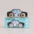 A wooden toy police car labeled GT255 SAM sits on top of its light blue packaging box. The car is painted white and black with a yellow star emblem, an American flag, and wood-grain wheels.