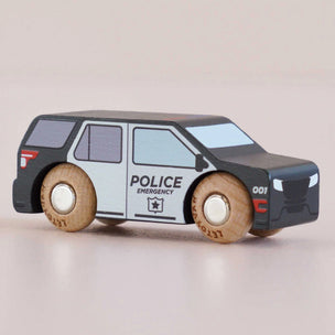 Toy police car with wooden wheels on a beige background
