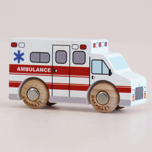 Wooden toy ambulance with red and white colors on a beige background