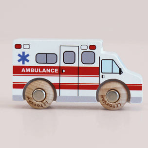 Wooden toy ambulance with wooden wheels on a beige background
