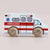 Wooden toy ambulance with wooden wheels on a beige background