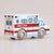 A wooden toy ambulance for children, featuring a white body with red stripes, a blue medical cross symbol, and realistic wooden wheels, shown on a neutral beige background.