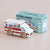 Wooden toy ambulance with 'LE TOY VAN' packaging on a beige background