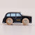A wooden toy taxi car with a black body, light blue windows, and natural wood wheels, shown on a plain light beige background.